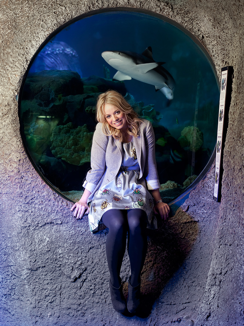 Editorial portrait of Liz McClarnon in front of a shark tank.
