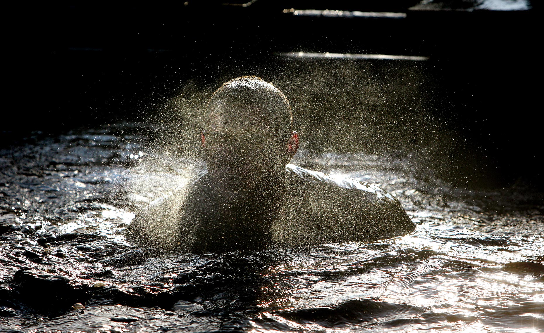 Editorial photography of competitors emerging from the water during Tough Guy. 