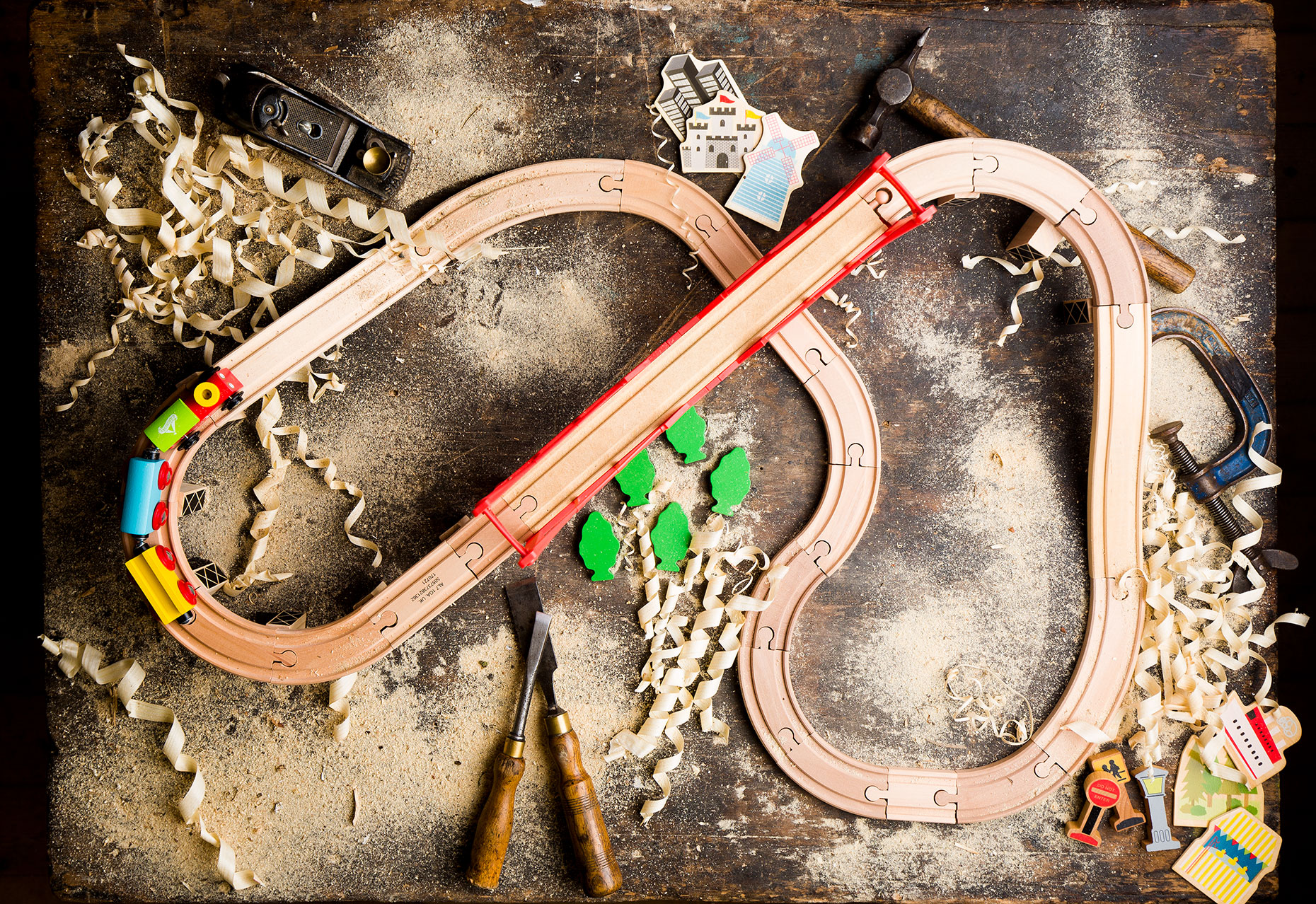 Editorial feature photography of a wooden toy train set in carpenters workshop.